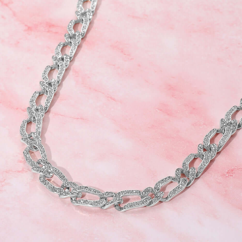 The Midnight Voltage Sterling Silver Dipped Necklace, featuring chunky textured links, is displayed on a pink marbled background.