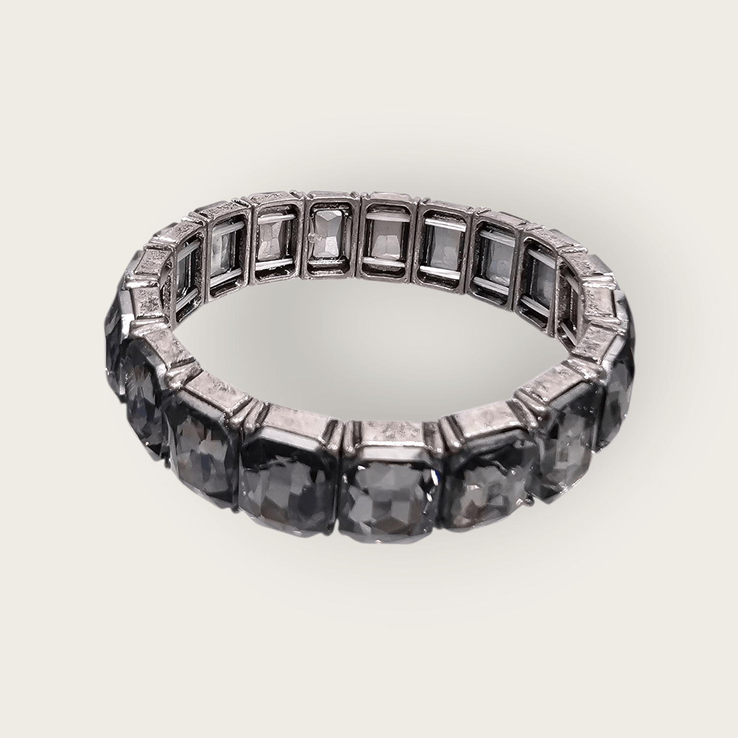 The Radiance Glow Stretch - Silver Bracelet features large square-cut smoky gray gemstones in individual metal settings; made in the USA.