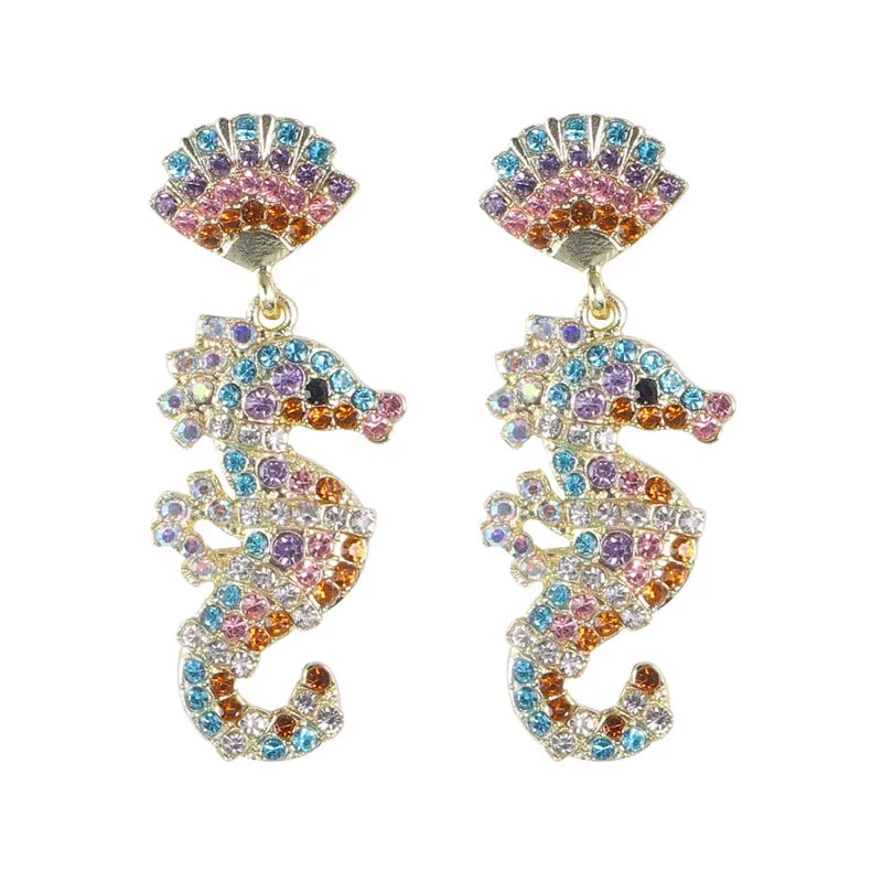 Ocean Elegance - Multi Seahorse Earrings feature silver-plated, seahorse-shaped drops and shell tops, both encrusted with blue, pink, purple, and orange gemstones. Displayed on a white background. Labor Day Sale.