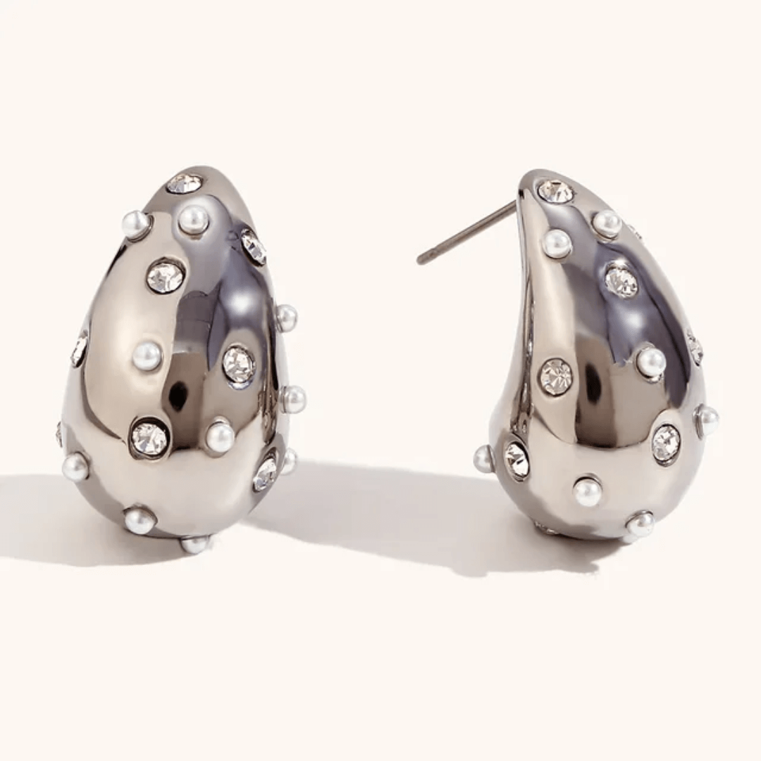 Bubble Luxe Earrings – Silver & White Pearl Stainless Steel Teardrop Earrings feature a shiny metallic finish, small round white pearls, and sparkling clear gemstones for an elegant look.