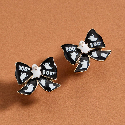 Halloween-themed earrings with ghost and 'BOO!' designs on a brown background