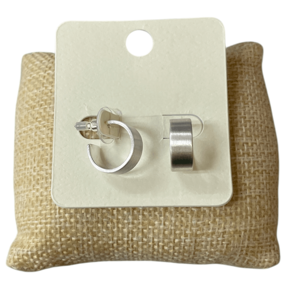 Brushed Bold - Silver Hoop Earrings: Minimal matte hoops on a white card, set on a textured brown cushion. Hypoallergenic and perfect for effortless style.